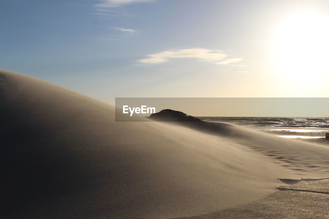 Scenic view of beach against sky during sunset