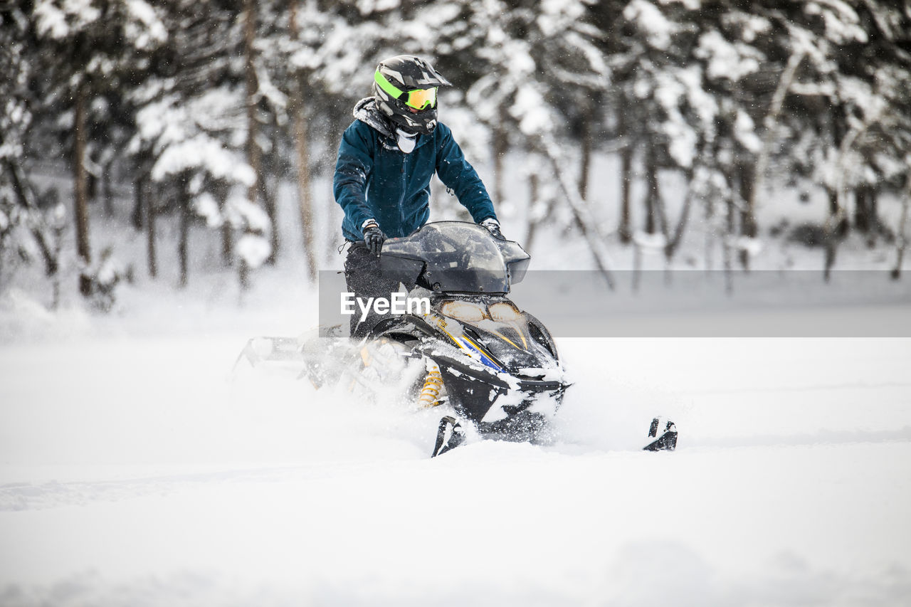 Front view of aggressive confident operator on snowmobile