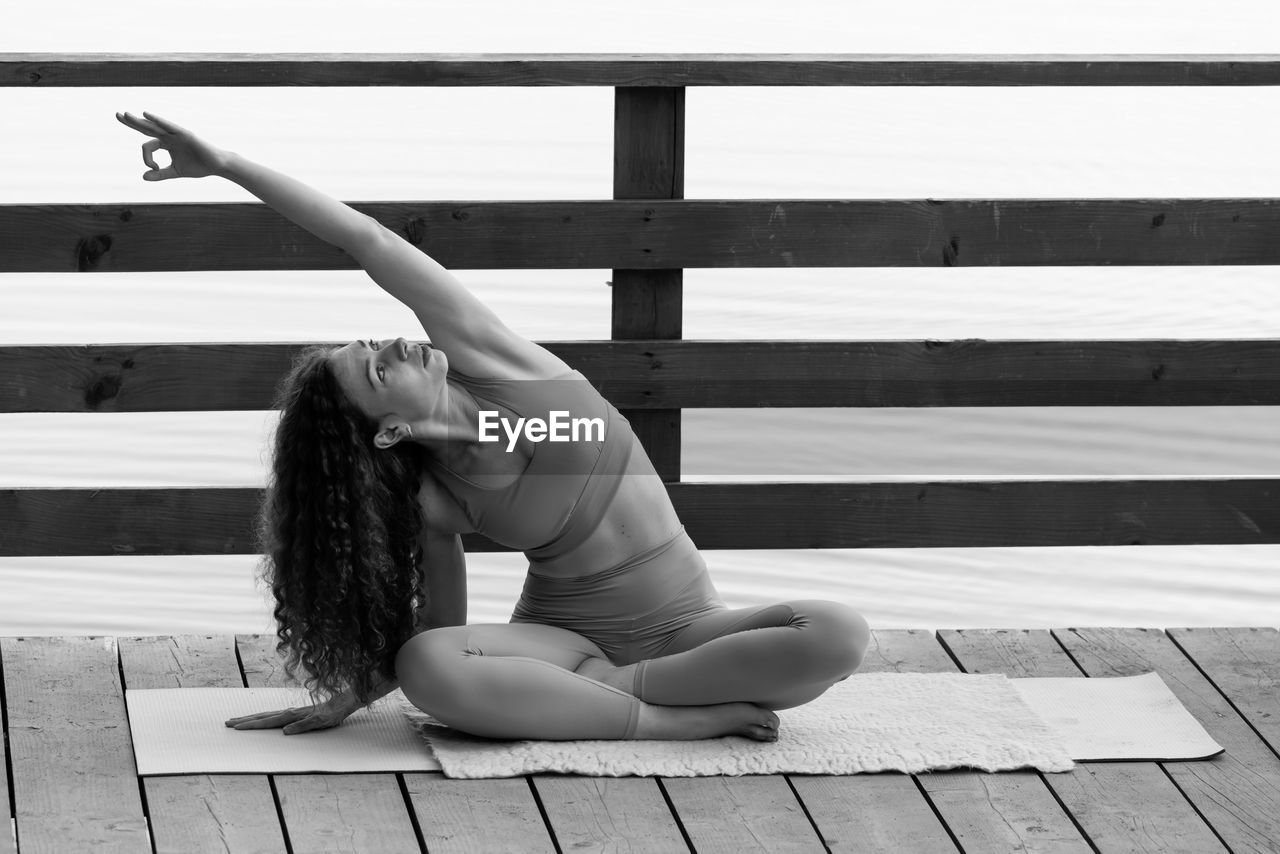 low section of young woman sitting on railing