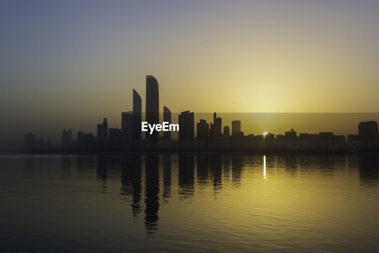 Abu dhabi cityscape silhouette during sunrise