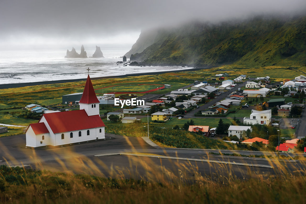 HOUSES BY SEA AGAINST SKY