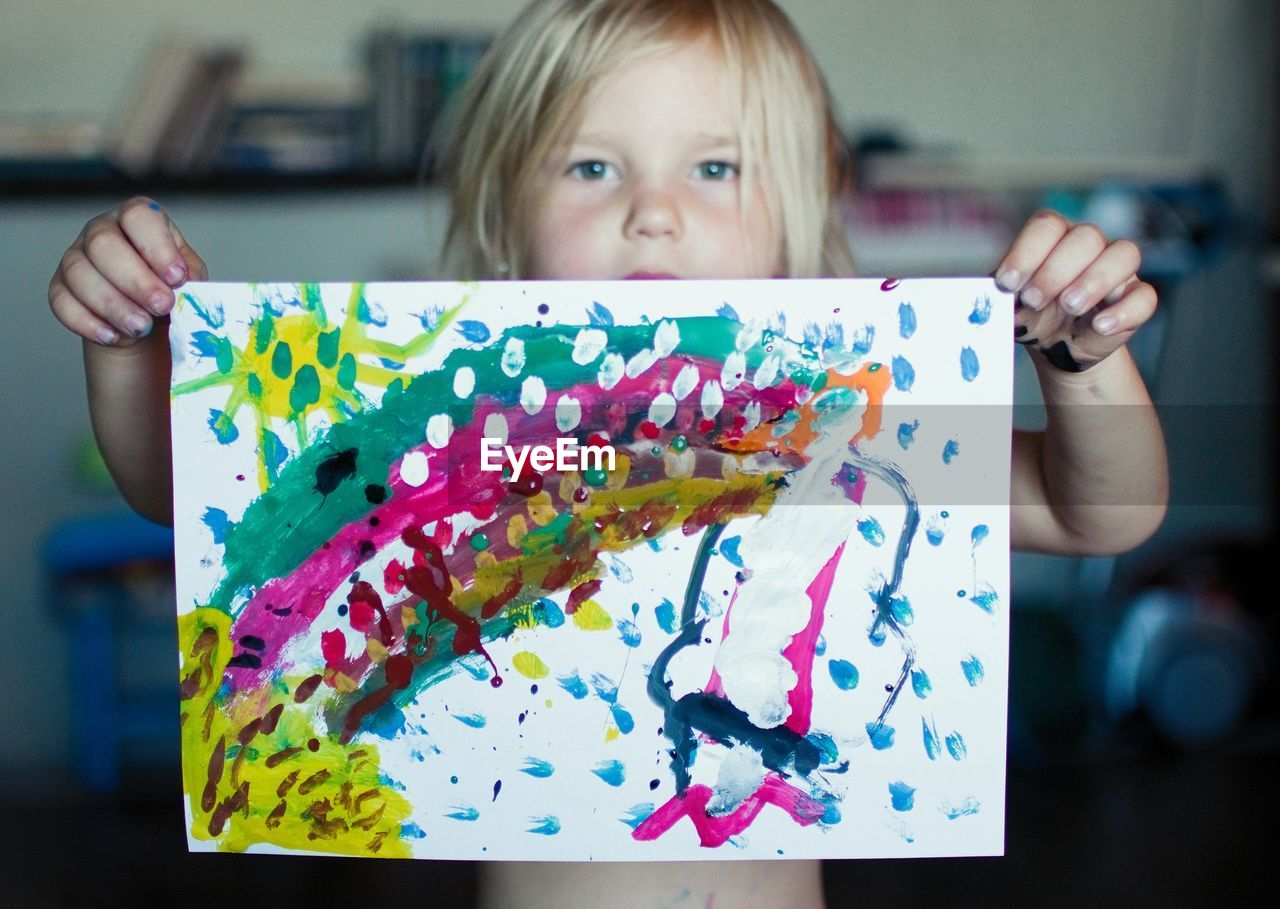 Portrait of girl holding colorful painting