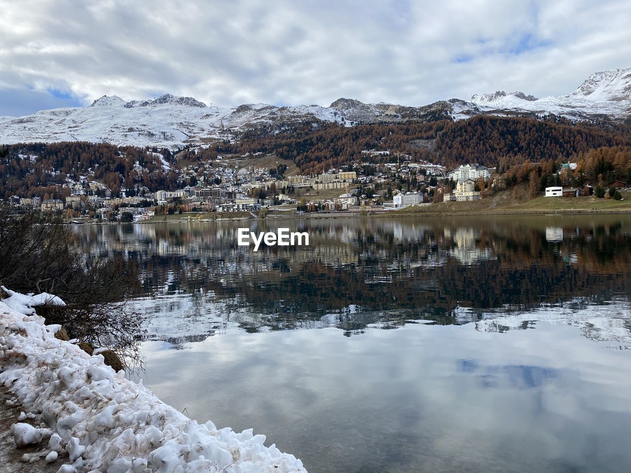 Scenic view of lake by snowcapped mountains against sky