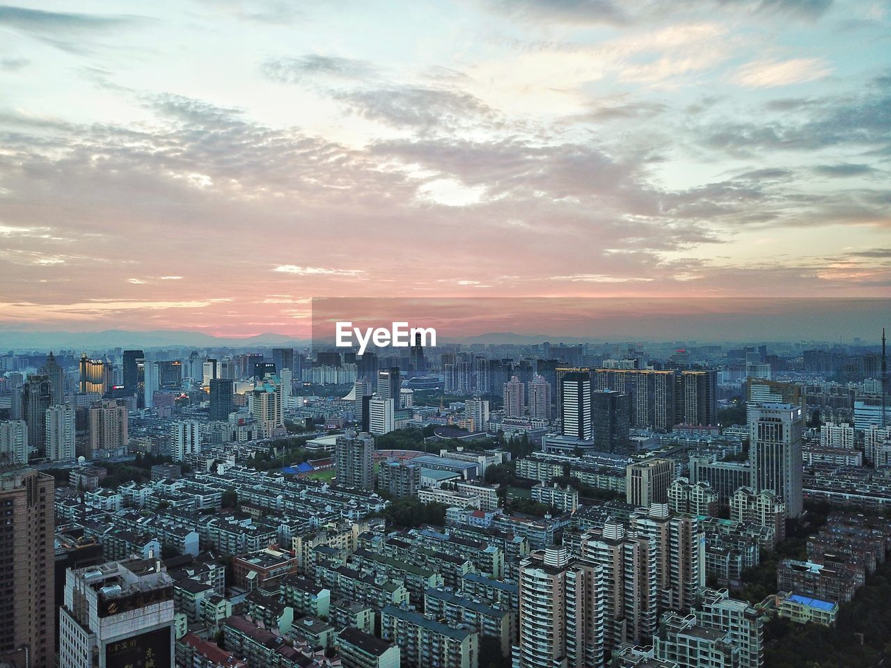 High angle view of modern buildings against sky during sunset