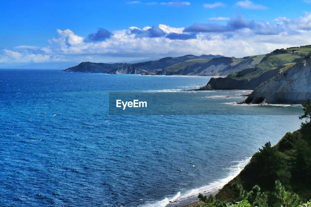 SCENIC VIEW OF SEA WITH MOUNTAIN RANGE IN BACKGROUND