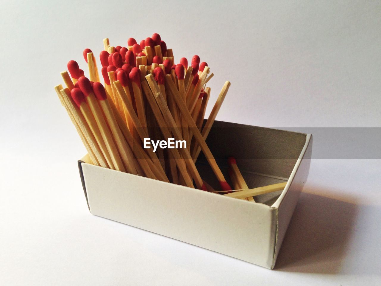 Close-up of matchsticks in box against white background