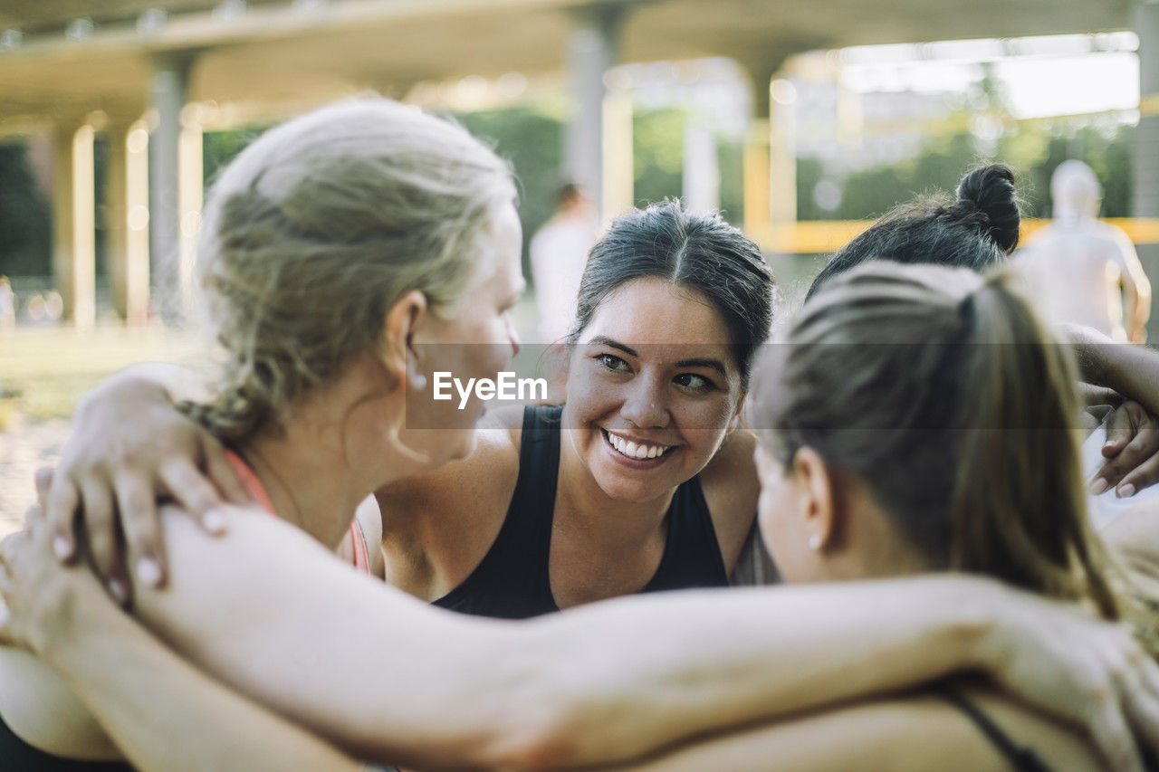 Smiling woman huddling with female friends