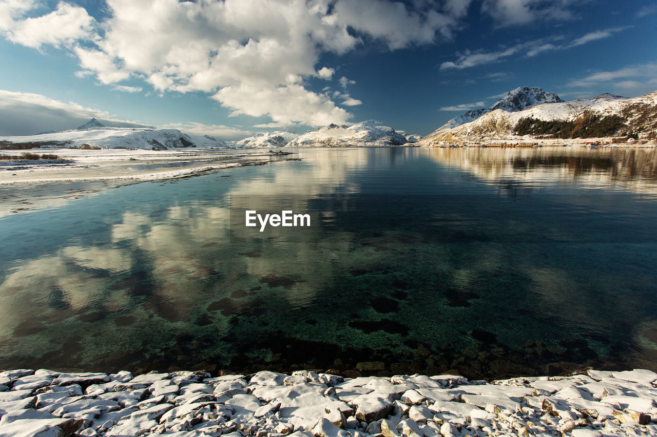 View of lake against mountain range during winter