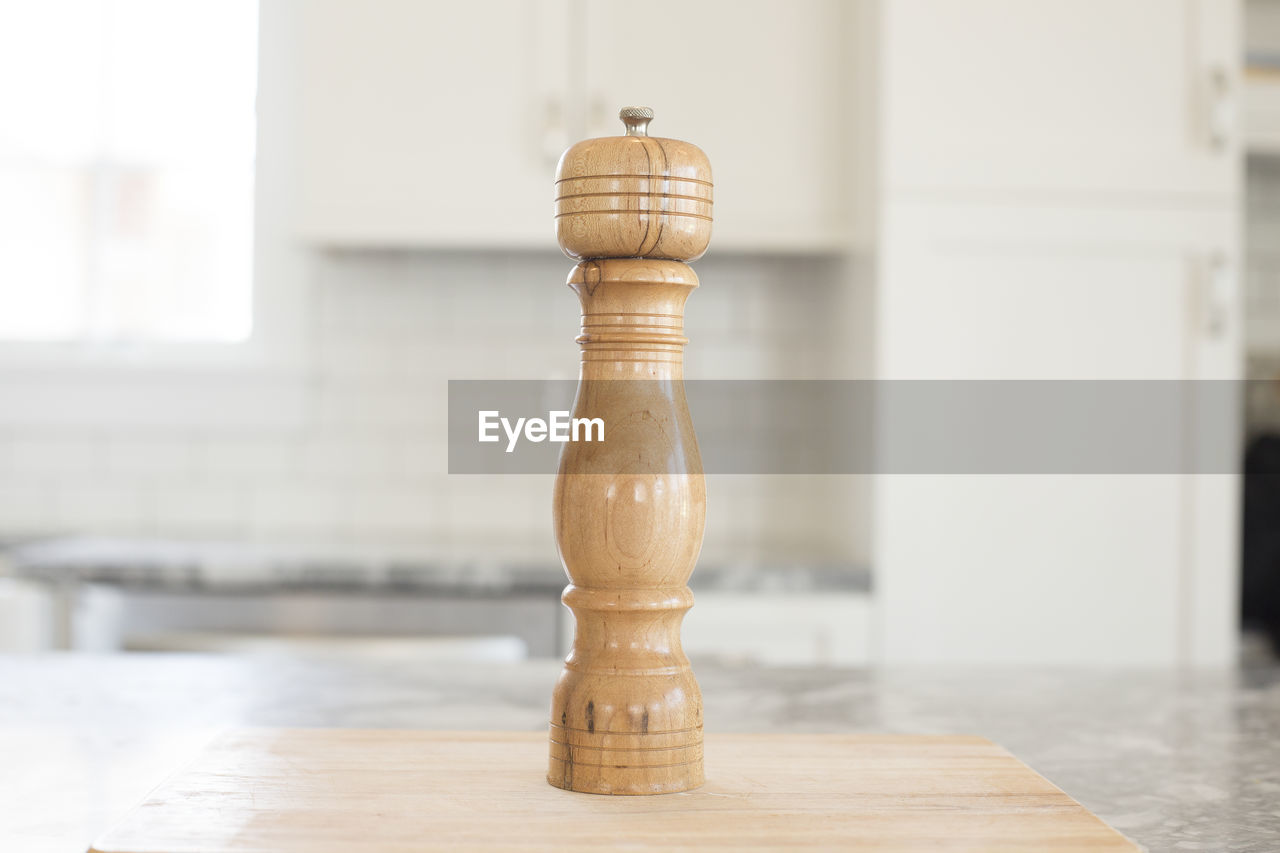 Close-up of wooden pepper mill on kitchen counter