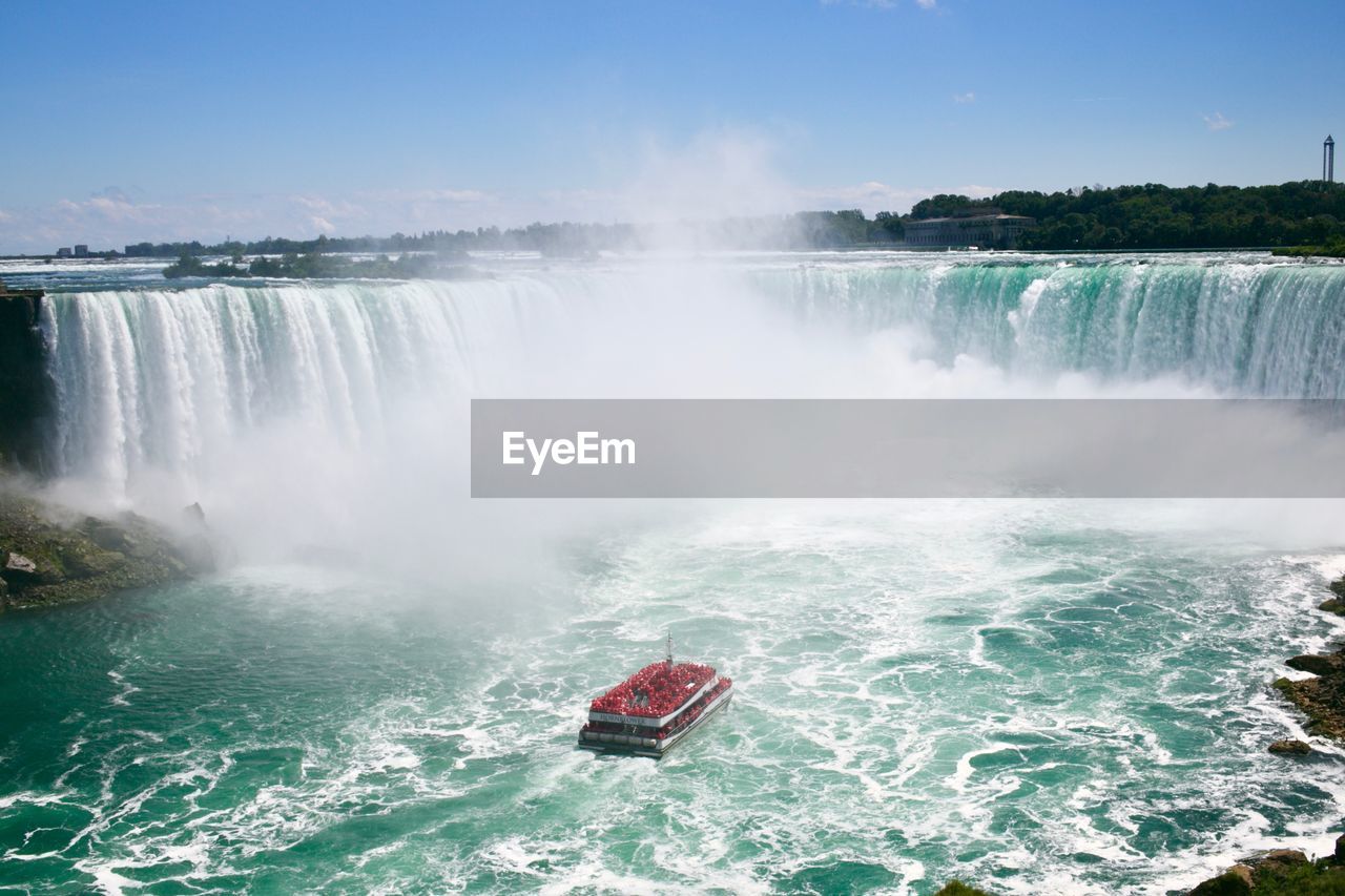 Scenic view of waterfall against sky