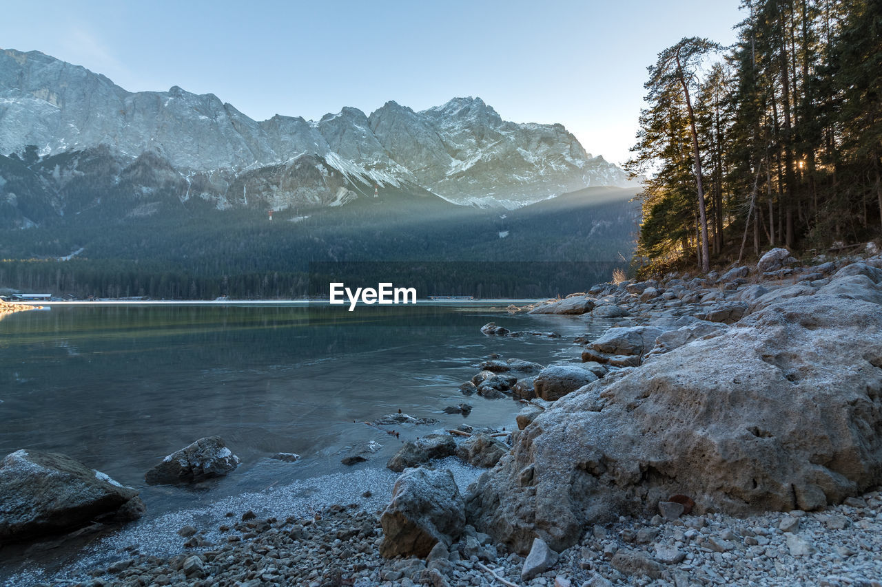 Scenic view of lake by mountains against sky