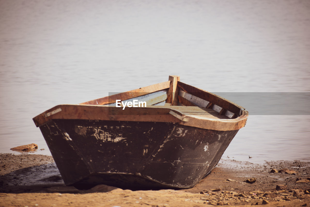 Abandoned boat moored on shore