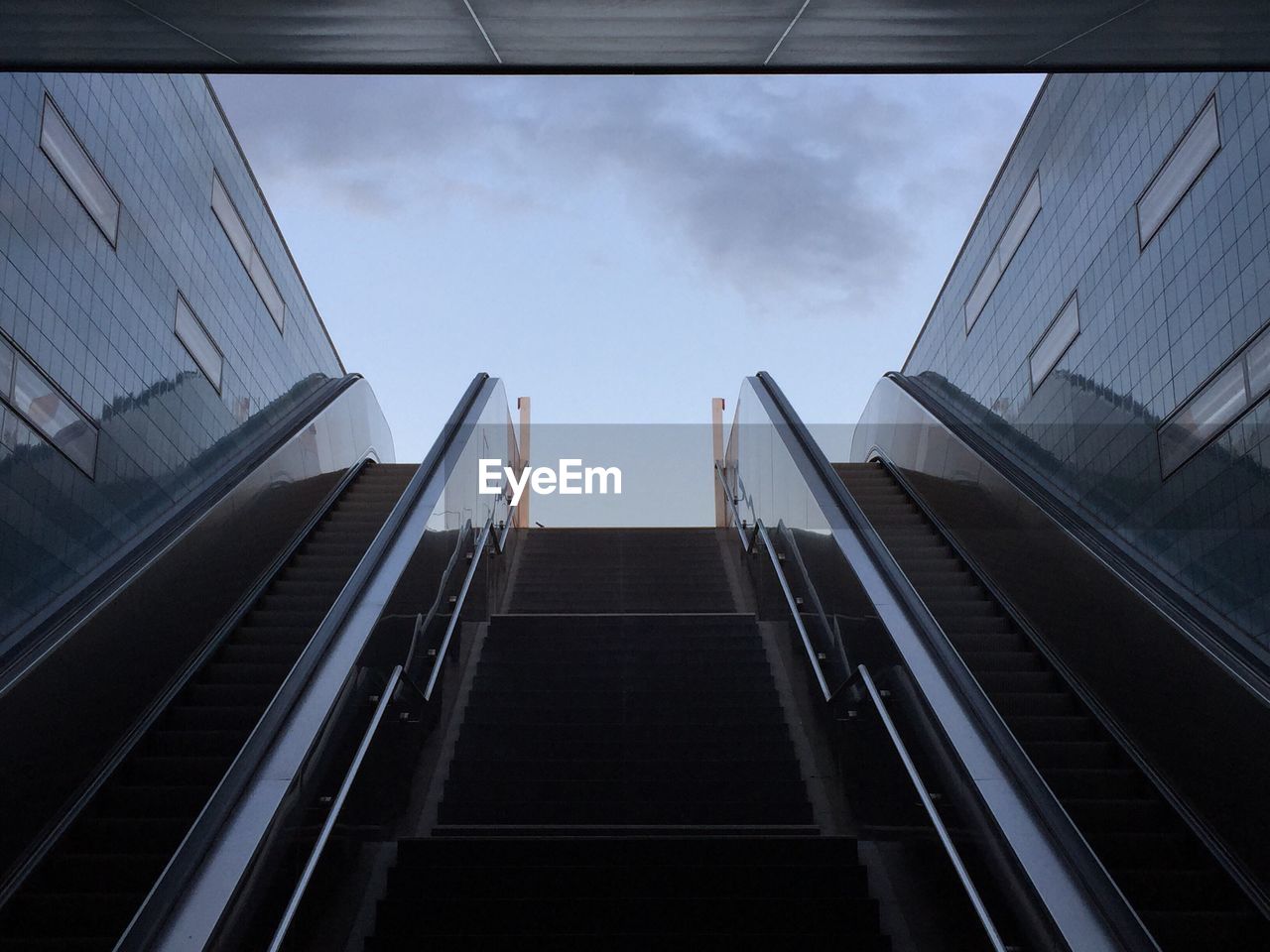 Low angle view of escalator against sky