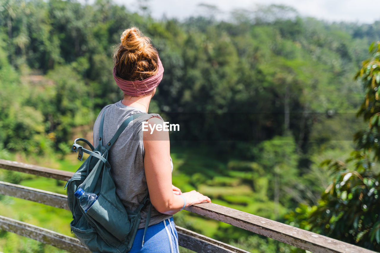 Rear view of woman standing by railing