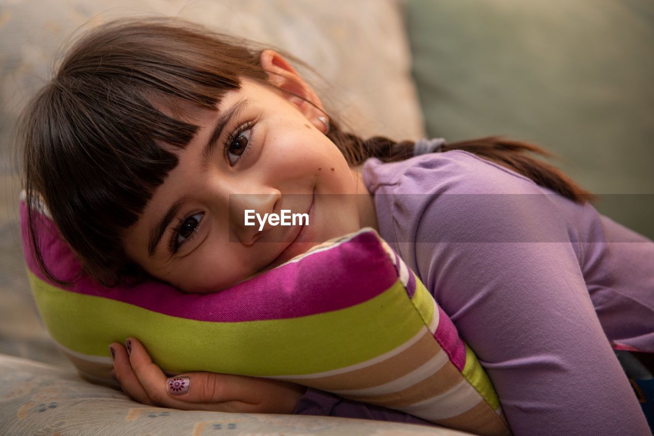Portrait of cute girl lying on sofa
