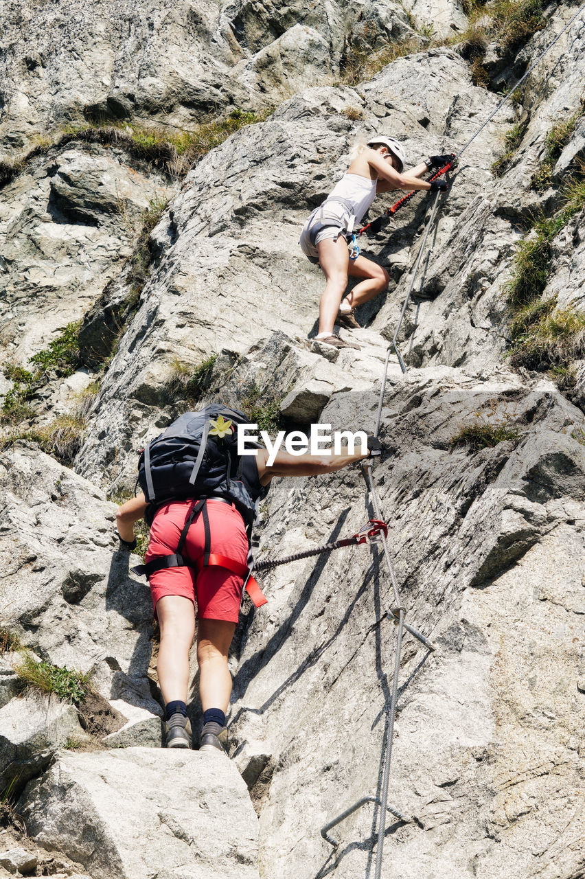 View of two women rock climbing at via ferrata, heini-holzer-klettersteig, merano