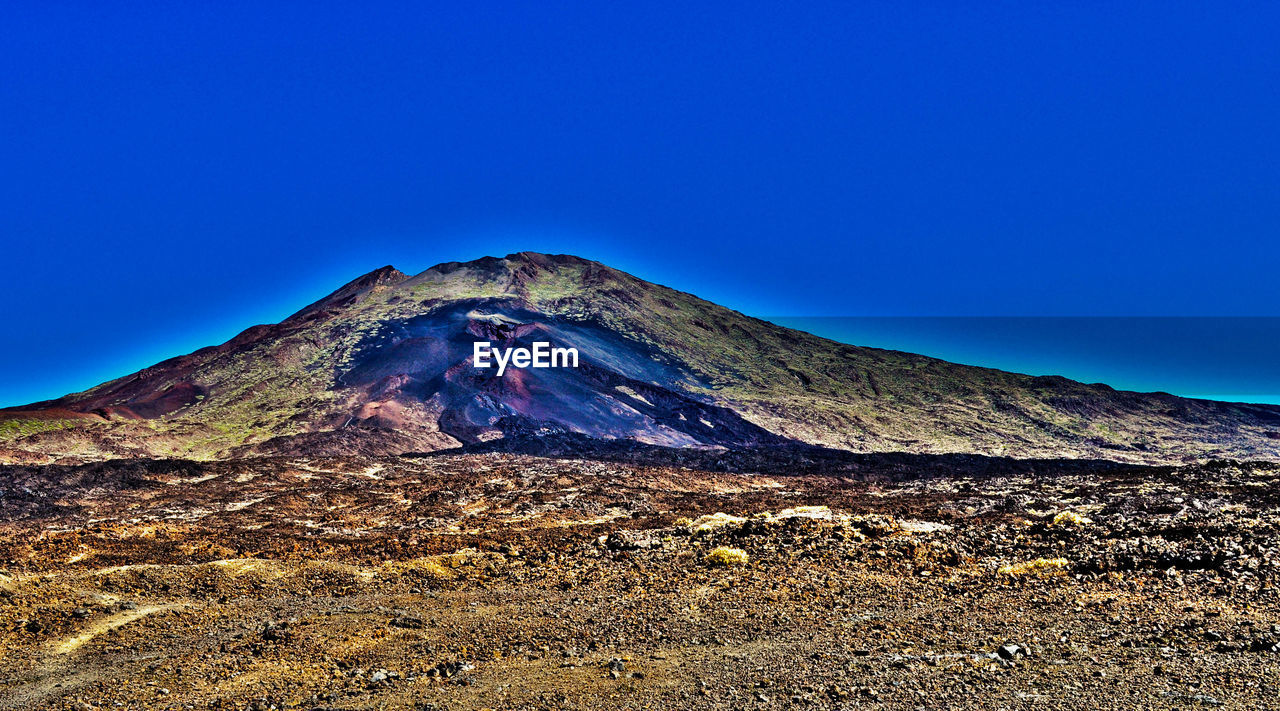 Scenic view of mountains against clear blue sky