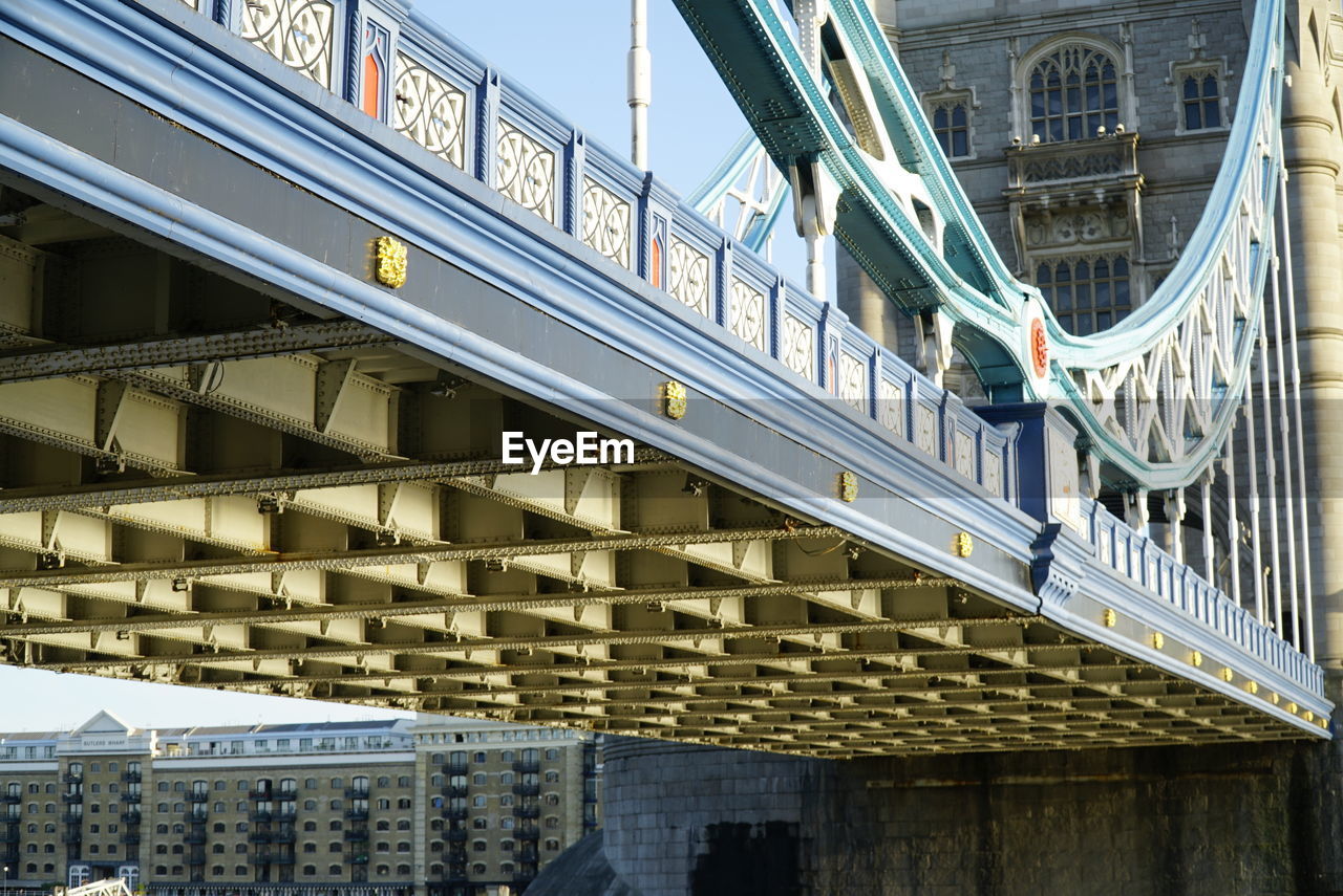 LOW ANGLE VIEW OF TEXT ON BUILDING AGAINST BRIDGE