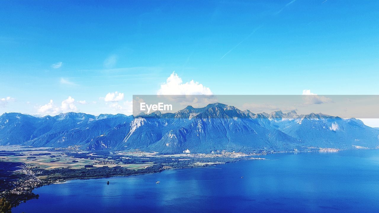 Scenic view of snowcapped mountains against blue sky