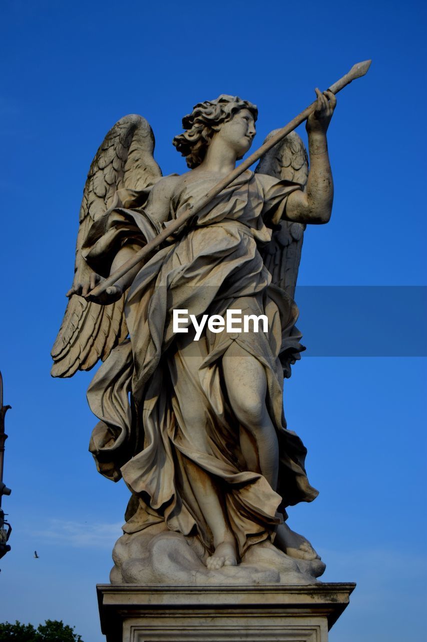 Low angle view of statue against blue sky