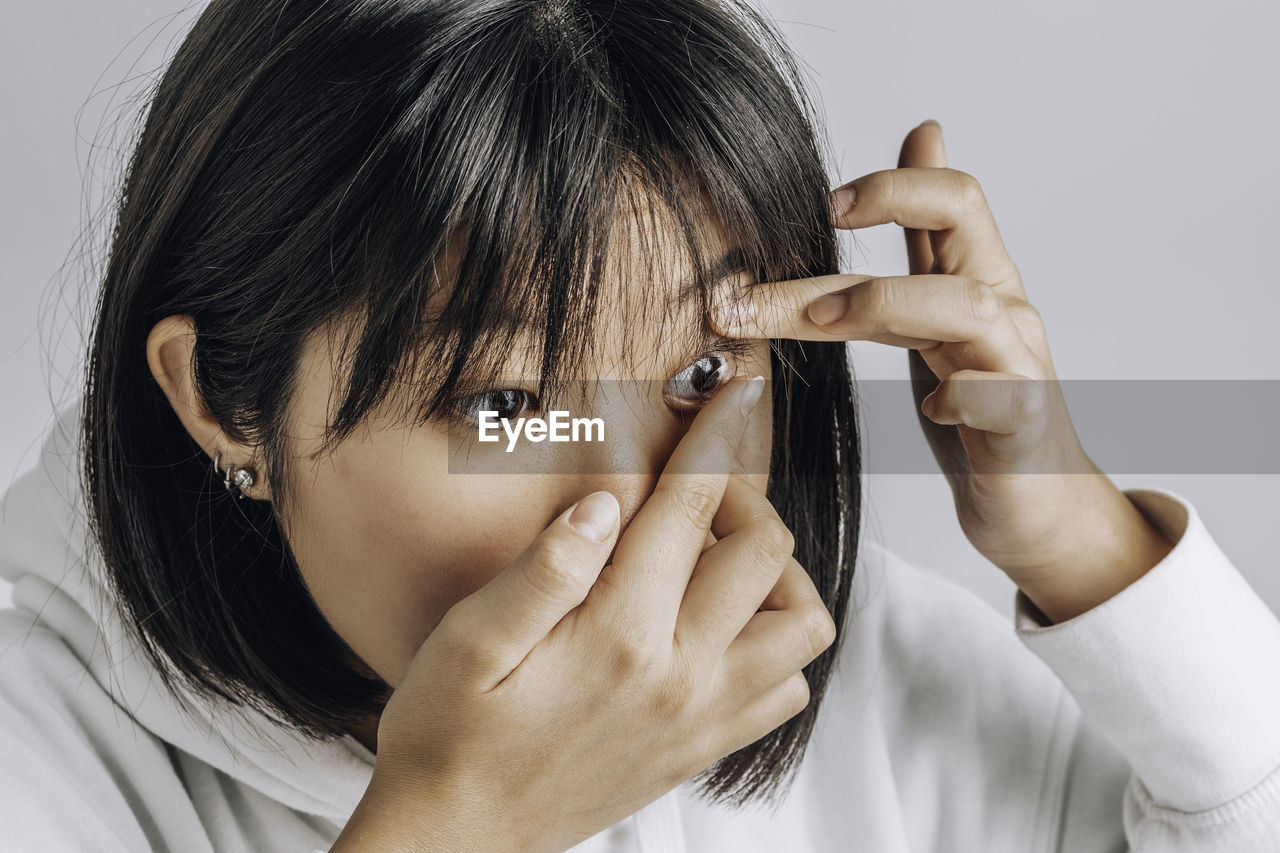 Close-up shot of young asian woman wearing contact lens. vision correction, medical products