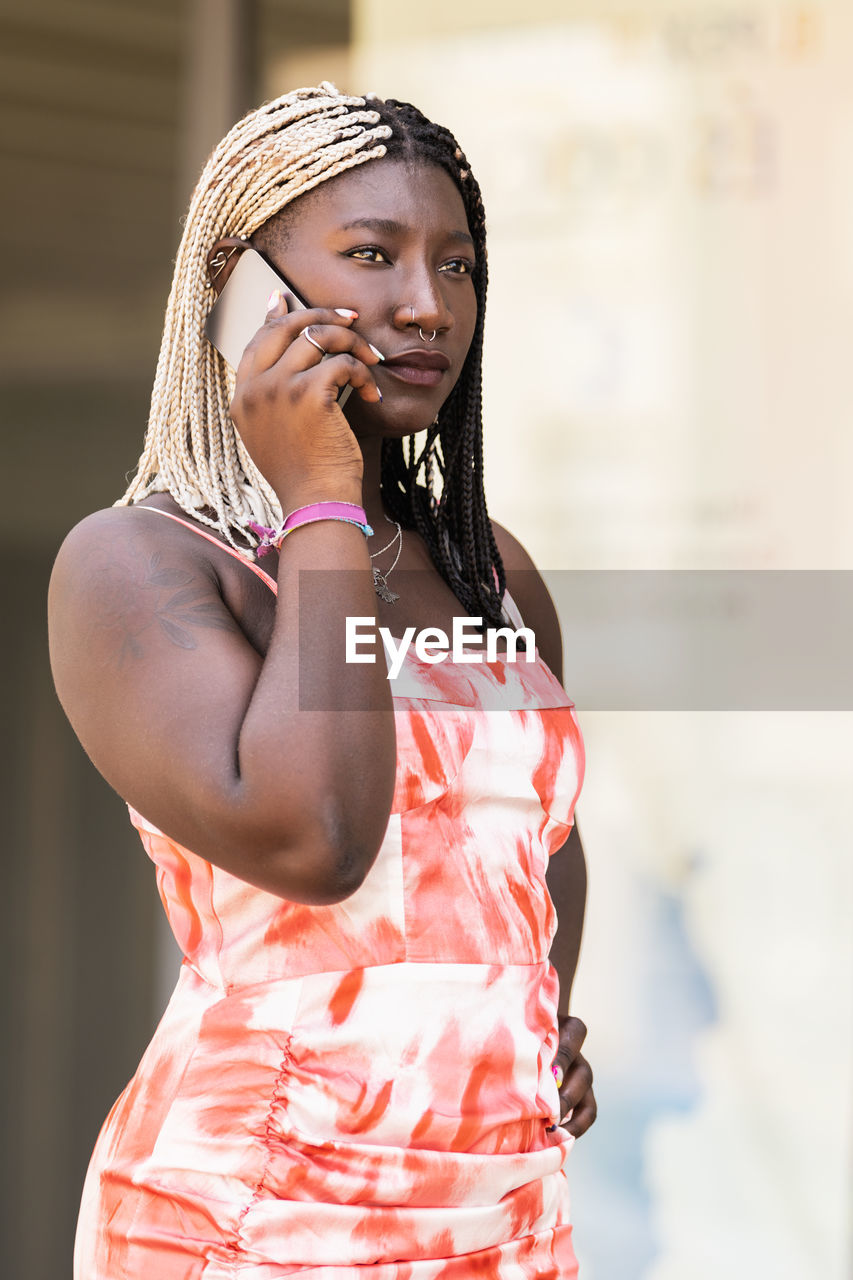 Young adult african woman talking with phone outside