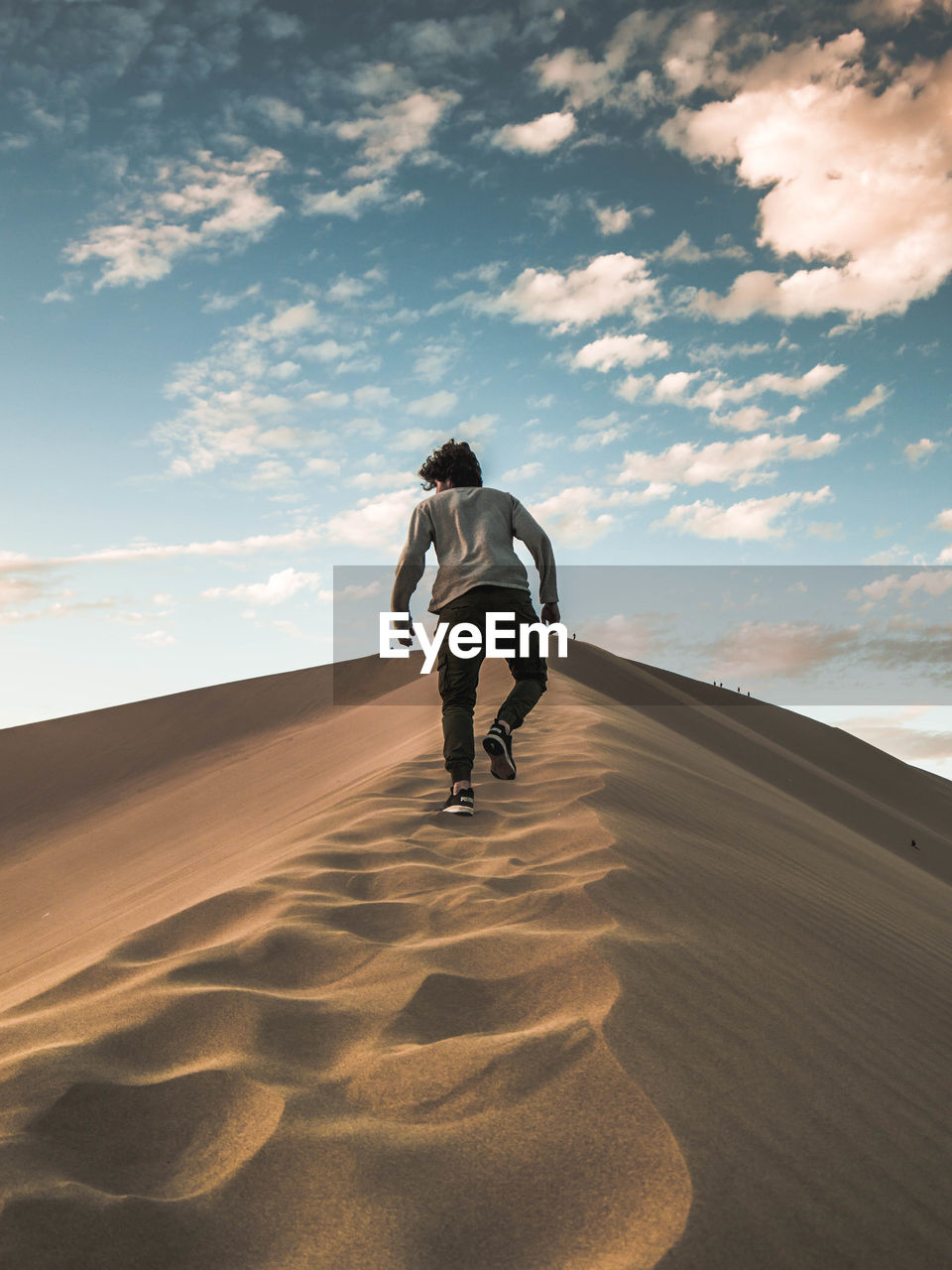 REAR VIEW OF MAN ON SAND AT DESERT