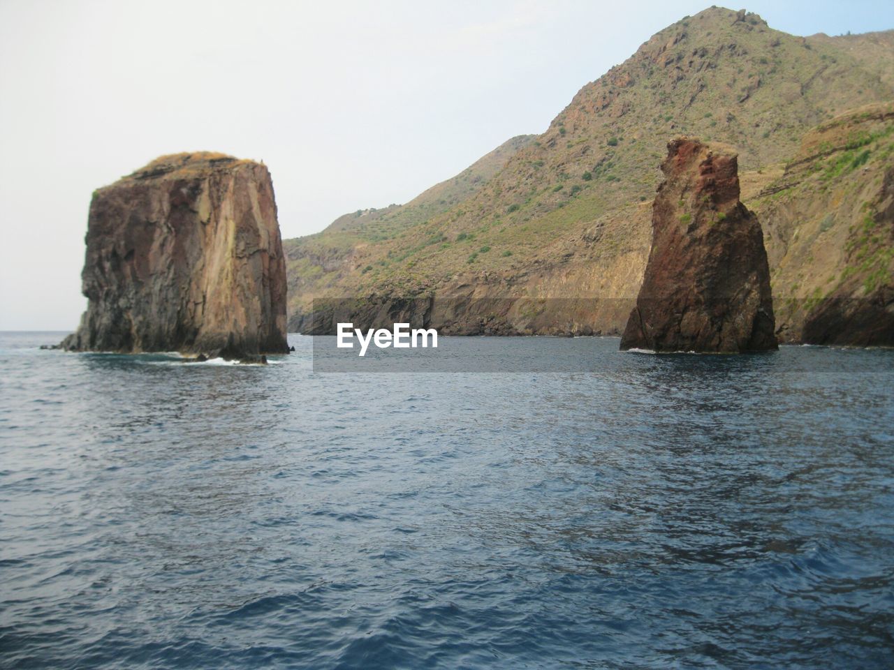 ROCK FORMATION IN SEA AGAINST SKY