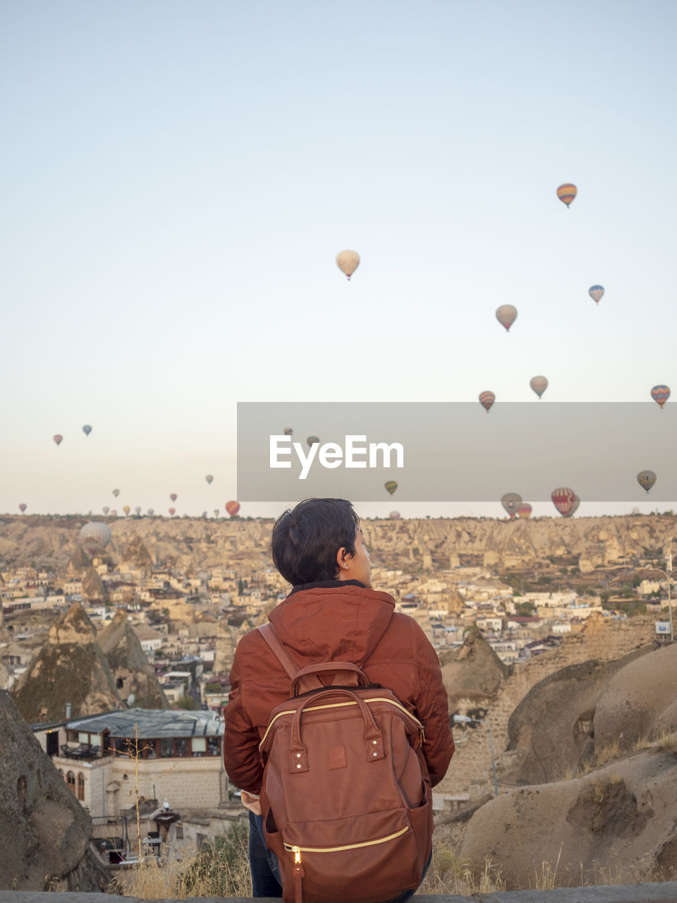 REAR VIEW OF MAN LOOKING AT CITY