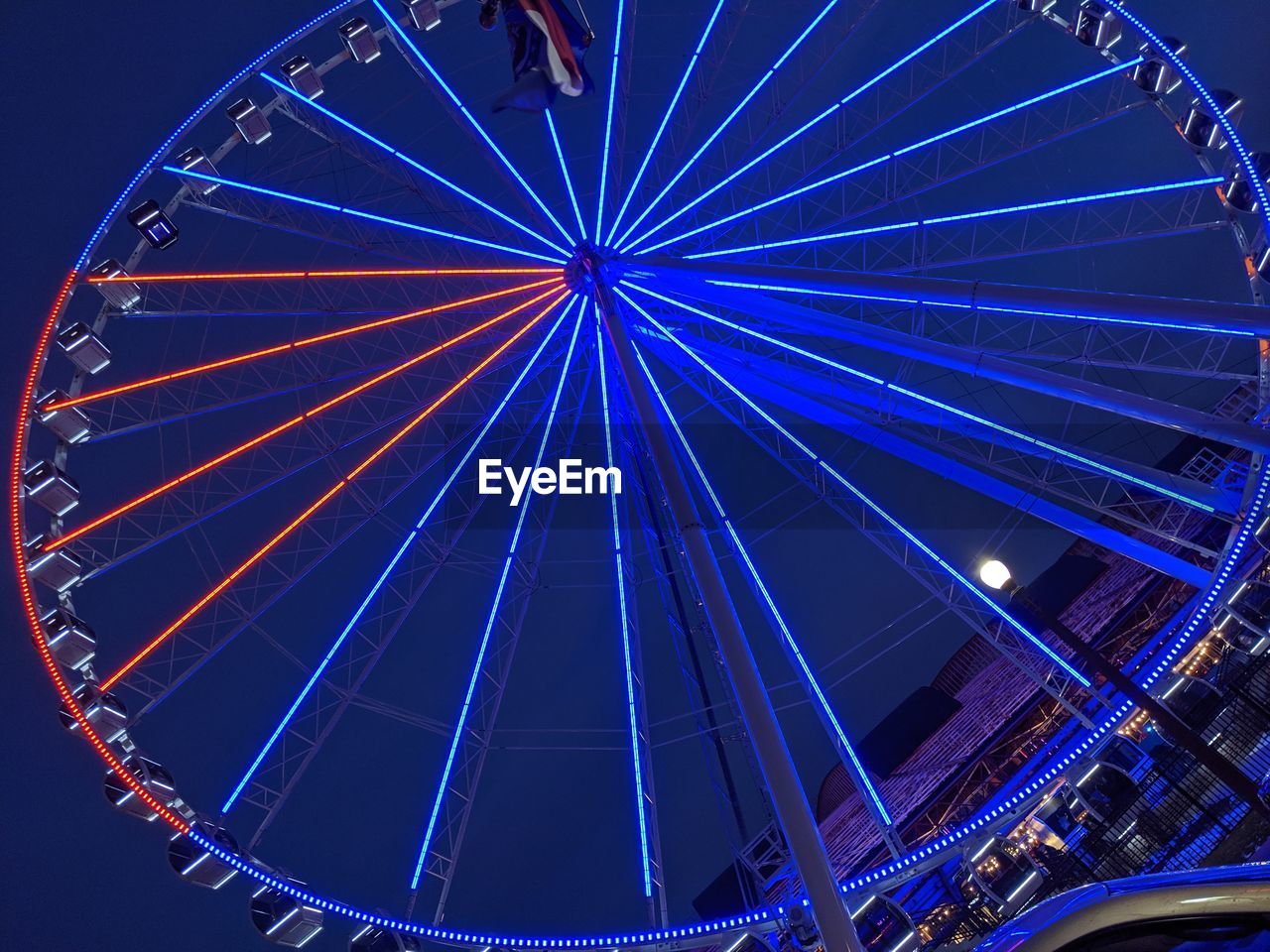 LOW ANGLE VIEW OF ILLUMINATED FERRIS WHEEL AT NIGHT