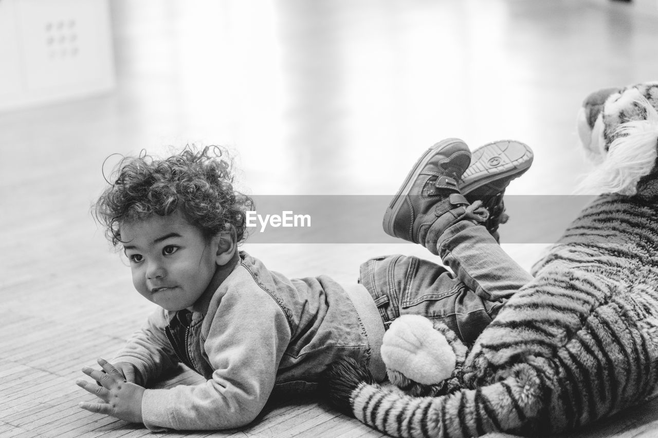 PORTRAIT OF BOY LYING ON FLOOR AT HOME