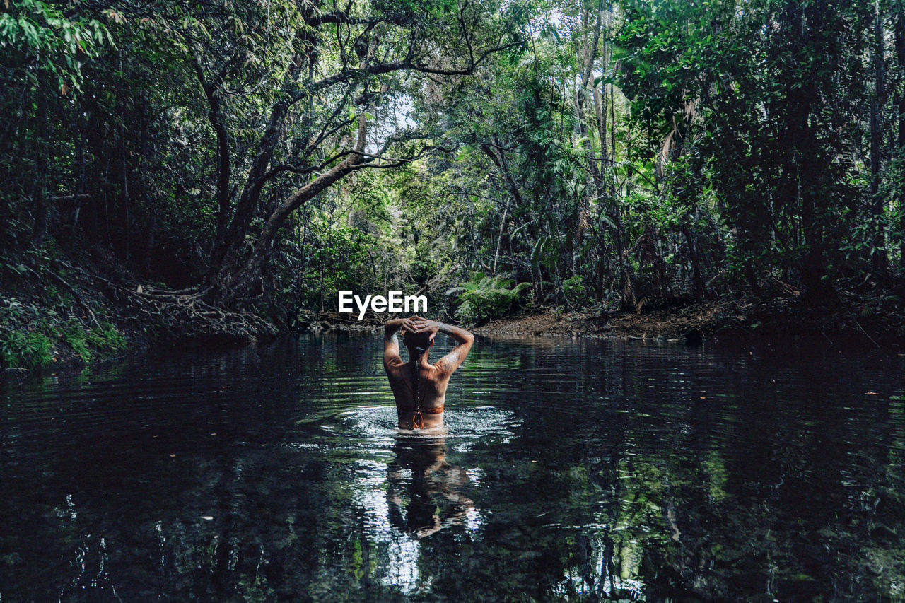 Back view of woman swimming in lake