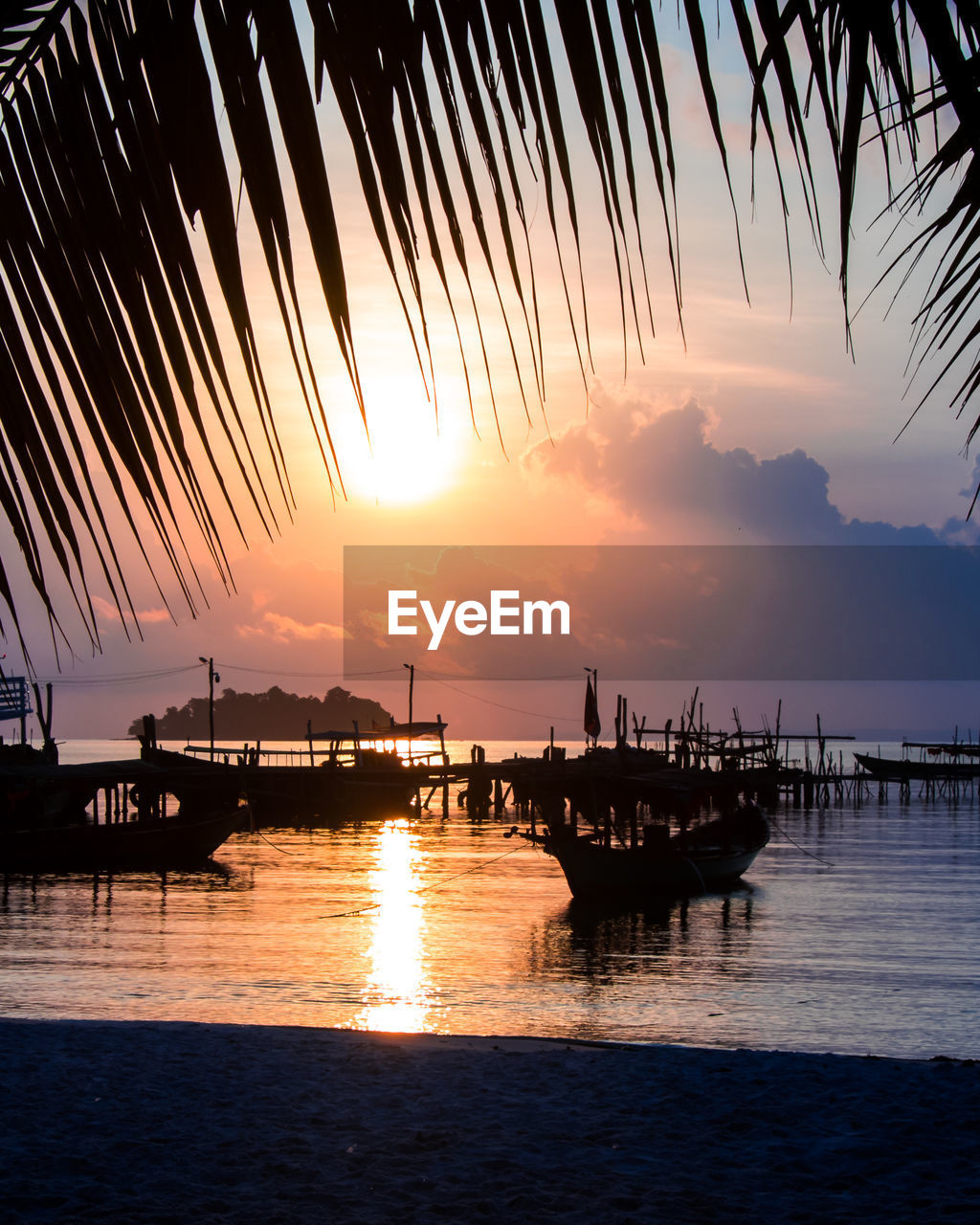 Silhouette boats in sea against sky during sunset