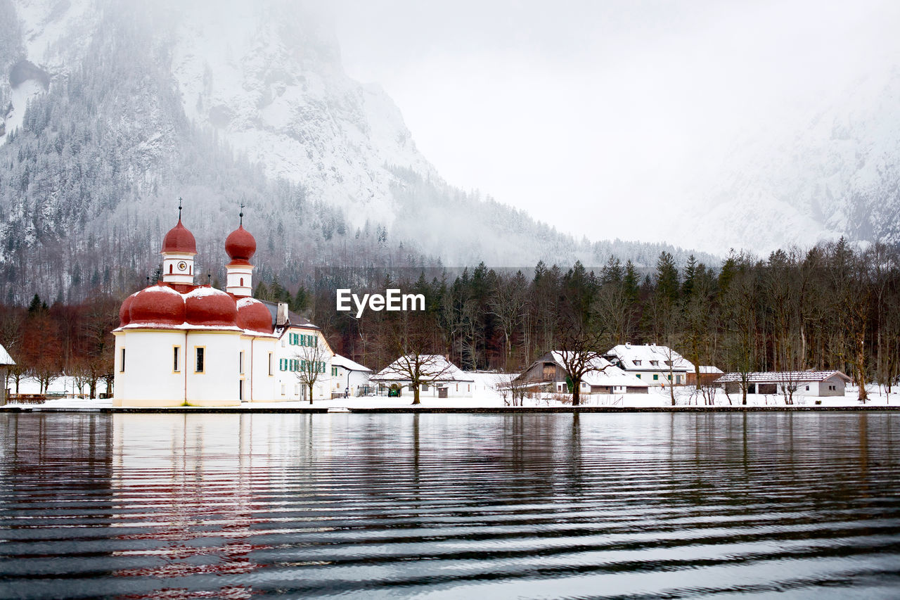 BUILDING BY LAKE AGAINST SKY