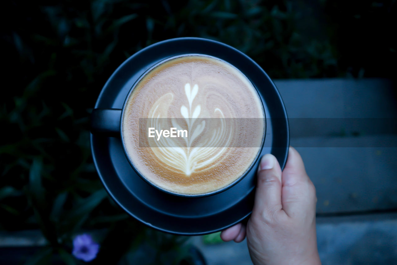 Close-up of hand holding coffee cup