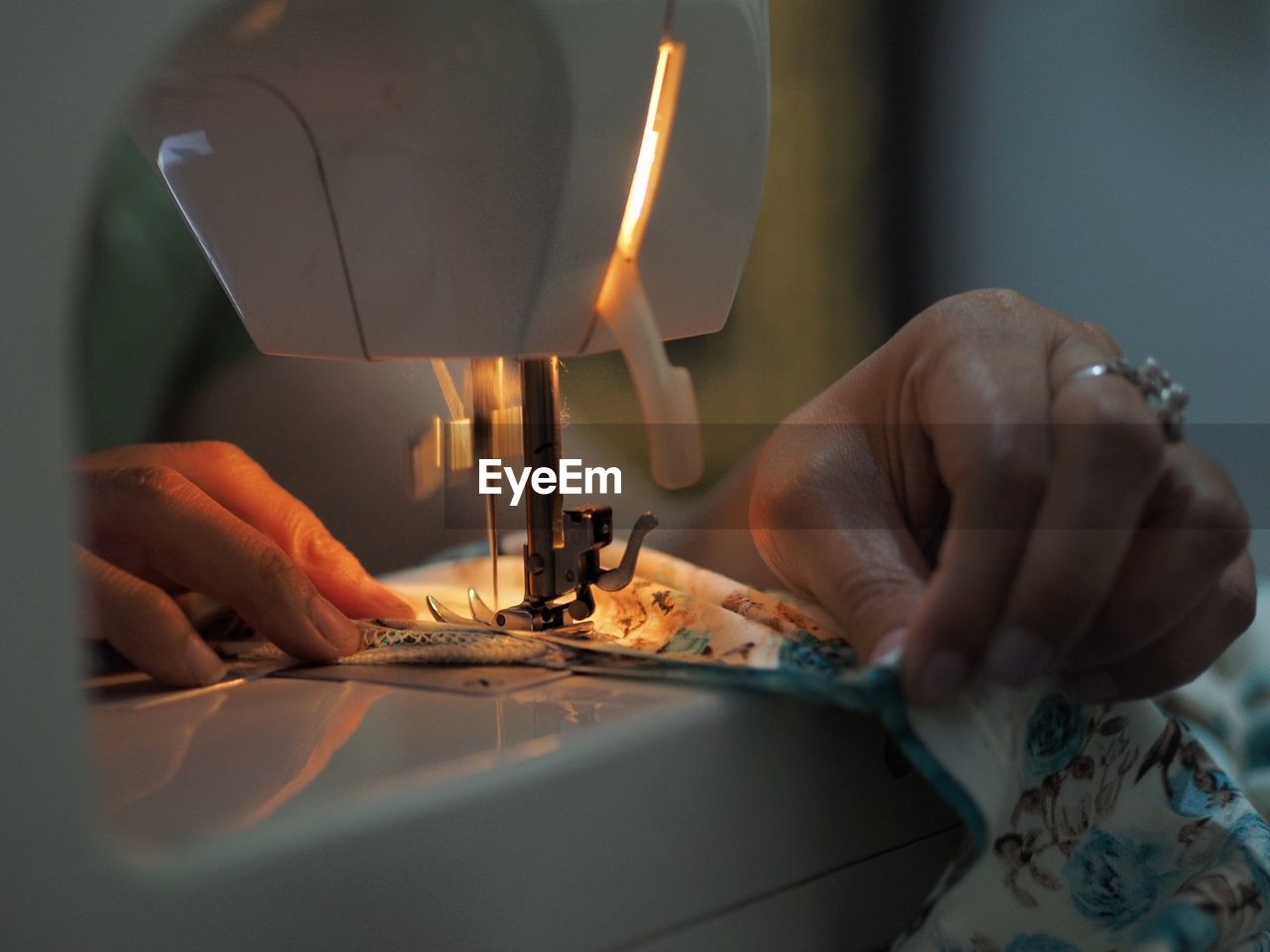 Close-up of woman stitching clothe on sewing machine