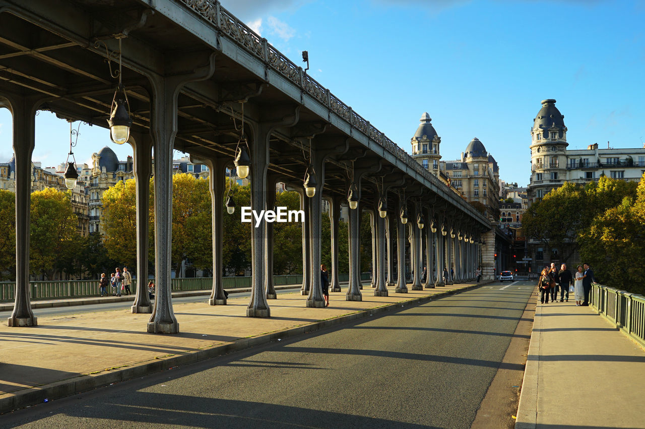 PEOPLE WALKING UNDER BRIDGE