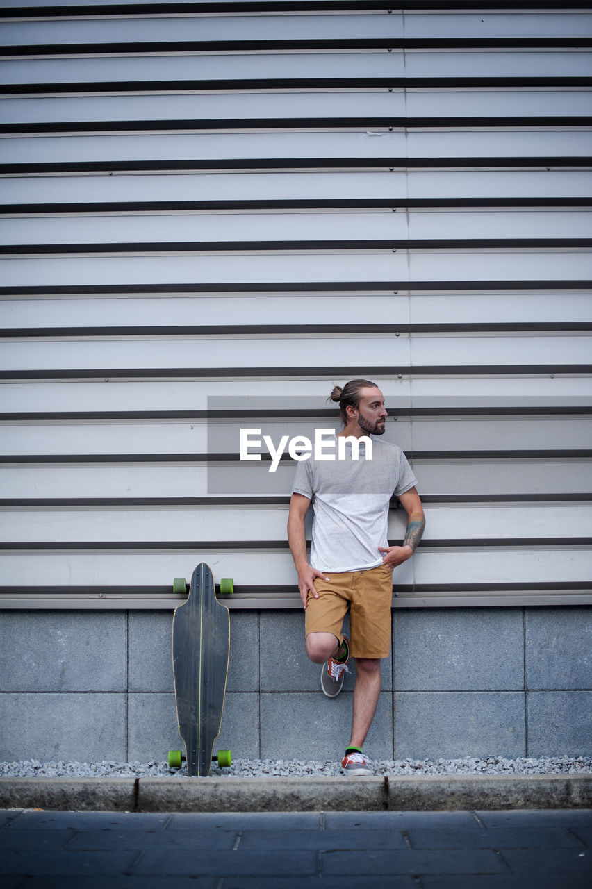 Boy posing with skateboard in hand