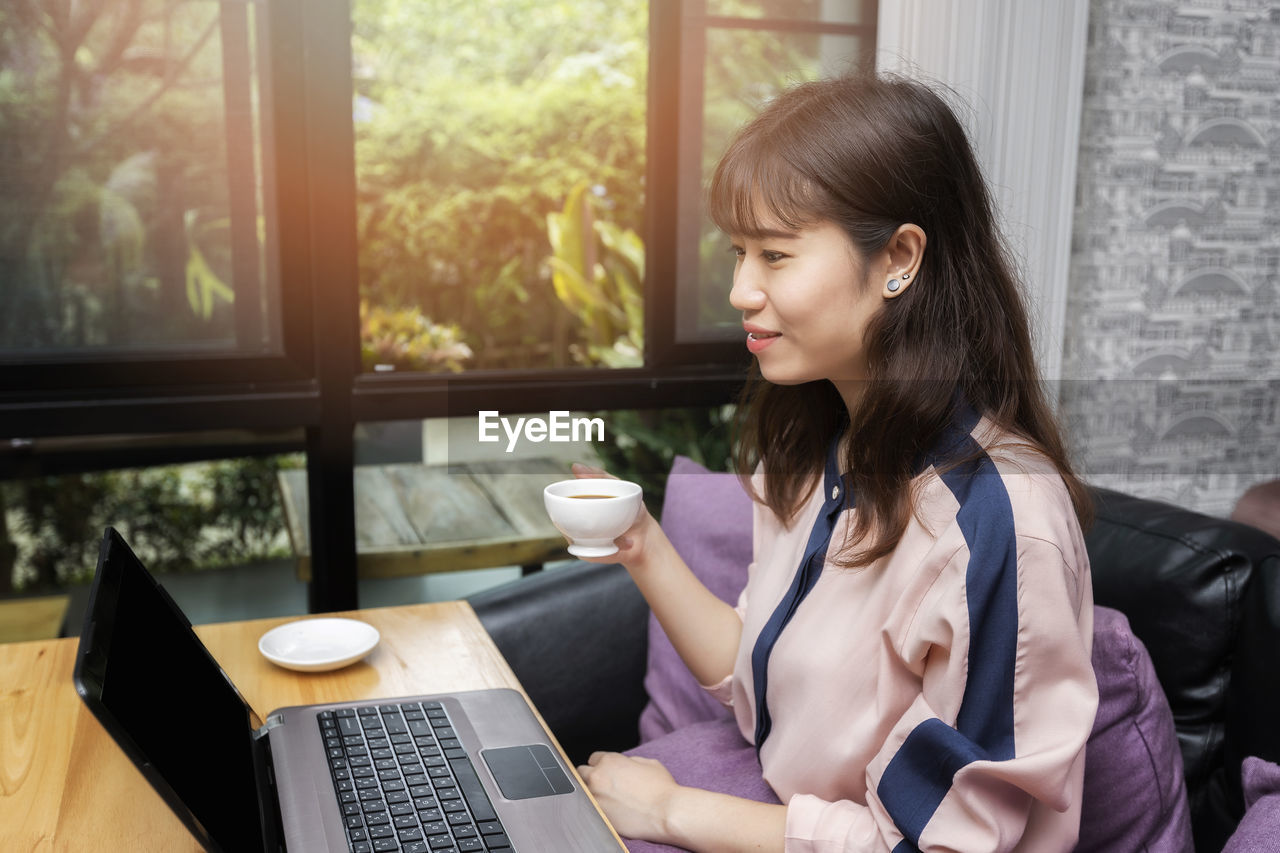 young woman using laptop while sitting at home