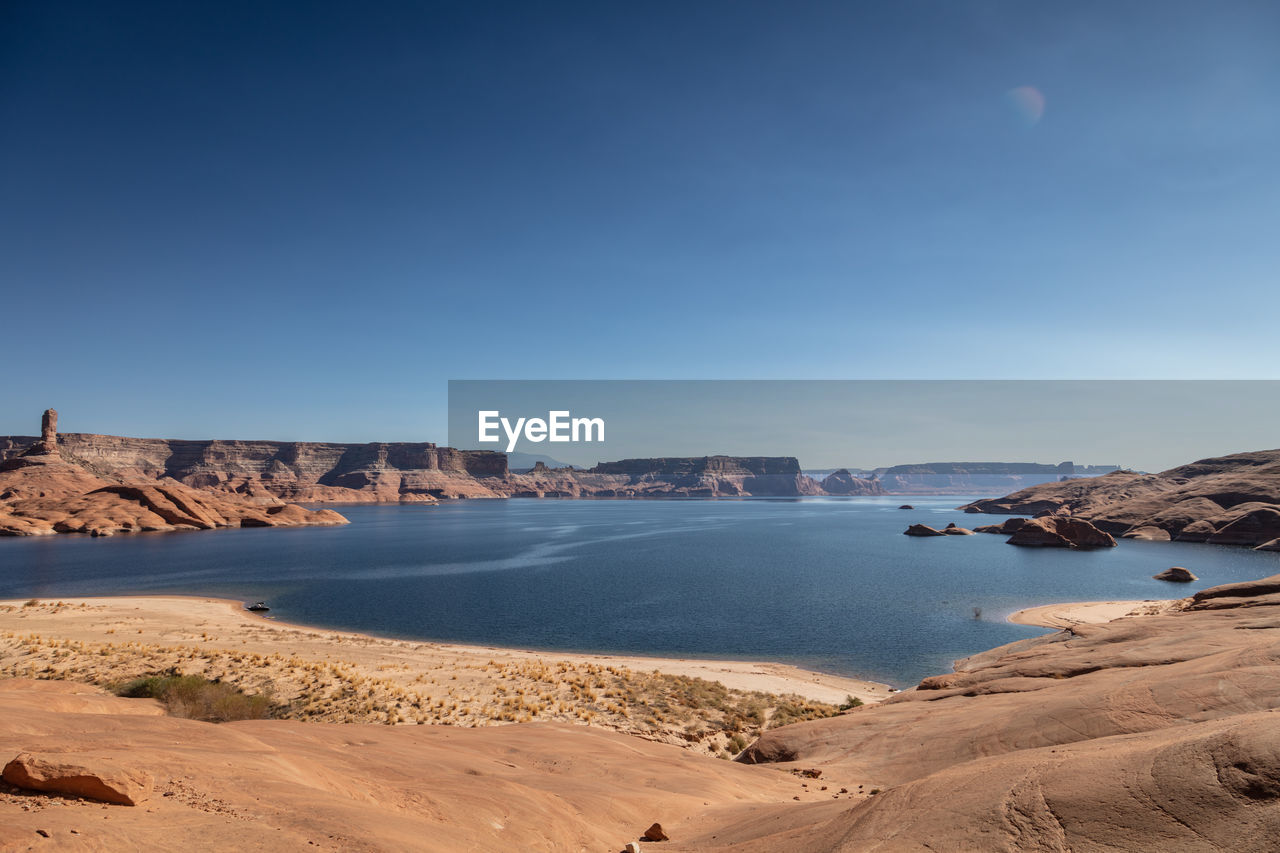 Scenic view of beach against clear blue sky