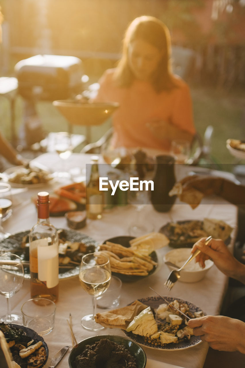 High angle view of friends enjoying dinner at dining table