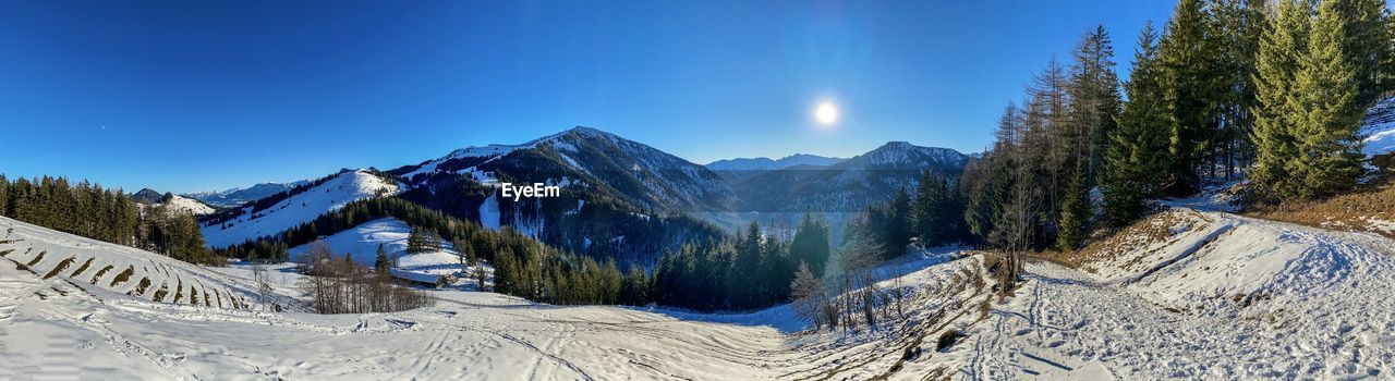 Panoramic view of snowcapped mountains against blue sky