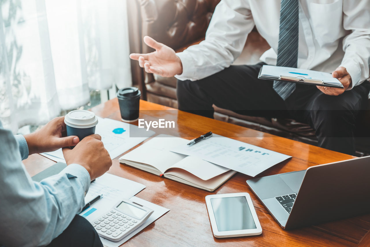 Cropped image of business colleagues working at desk in office