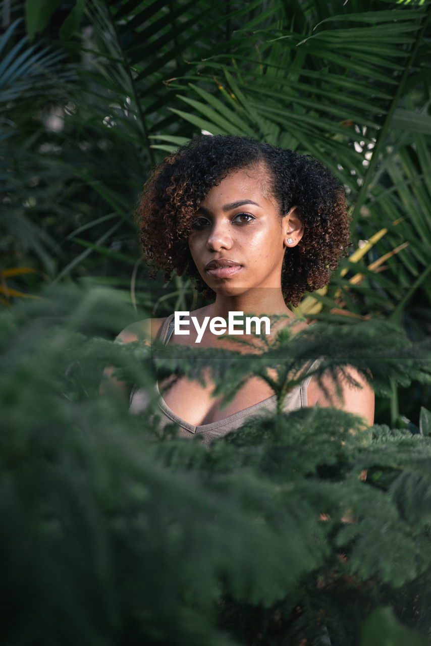 Portrait of young woman amidst leaves
