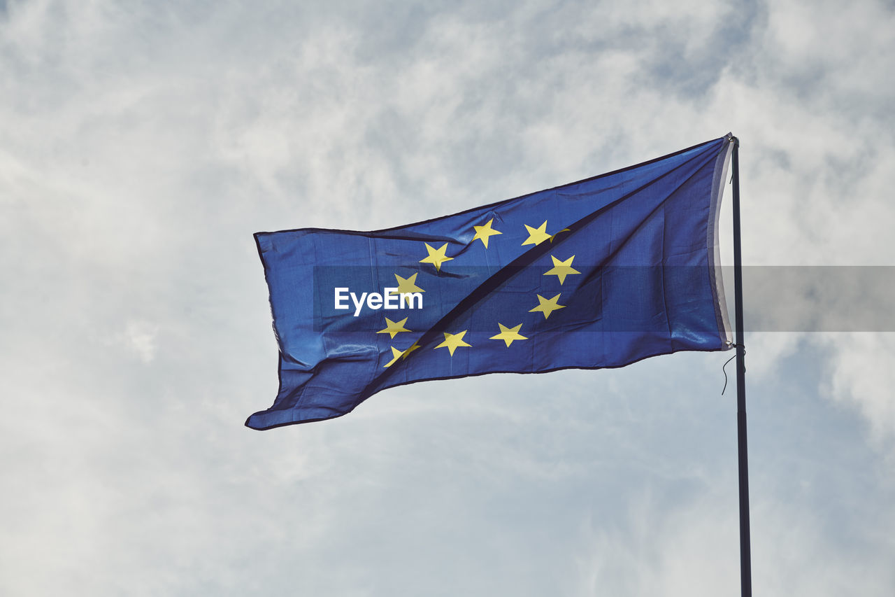 Low angle view of european union flag against blue sky