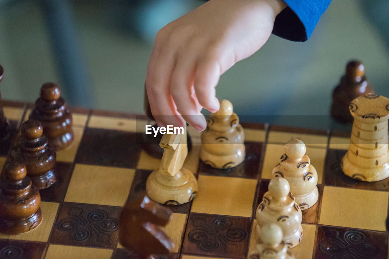 Cropped hand of child playing chess