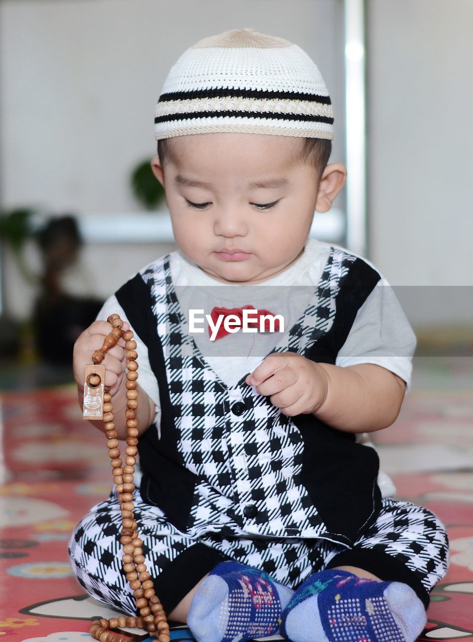 Full length of cute baby boy praying at home