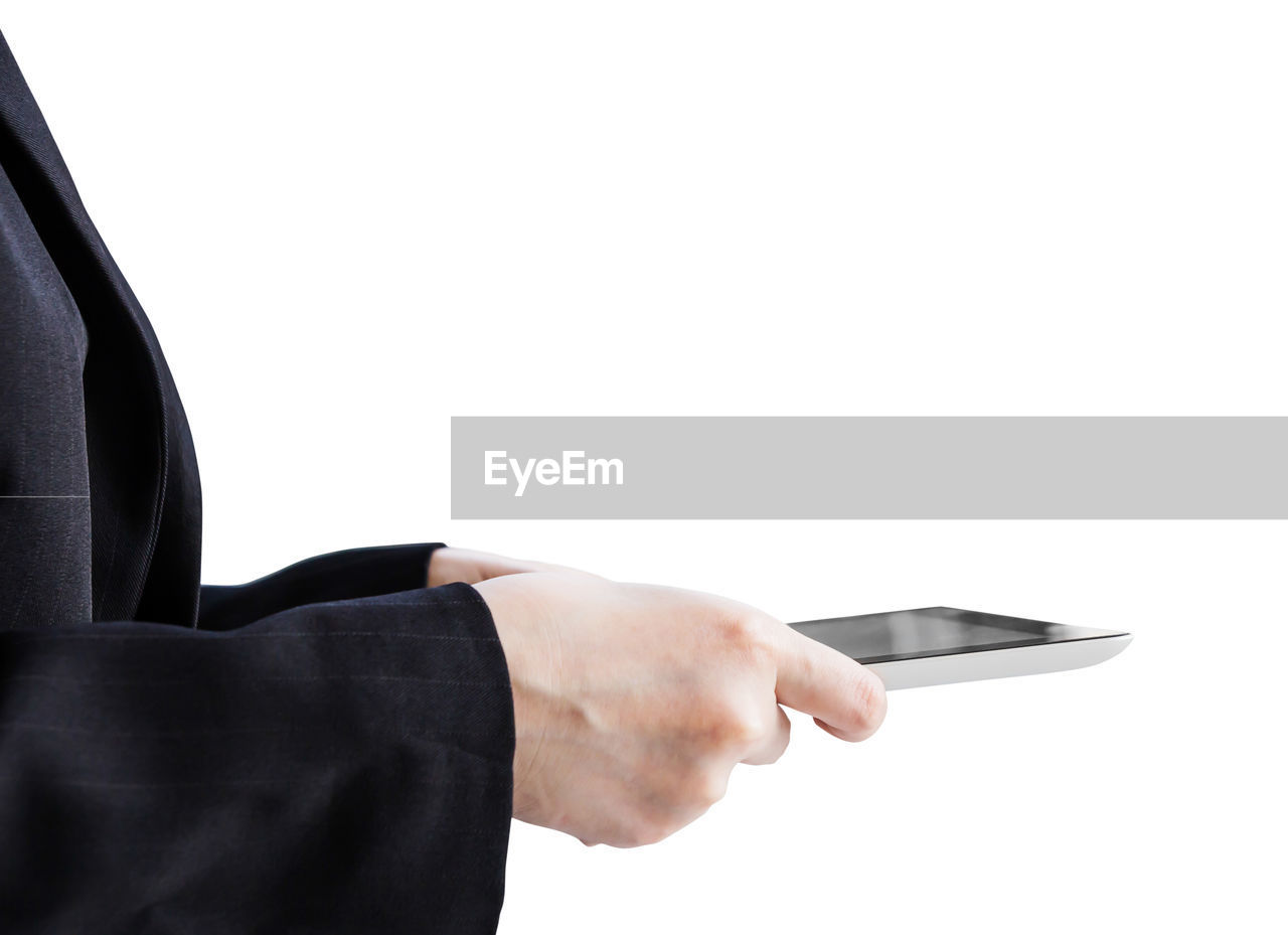 Cropped hand using digital tablet against black background