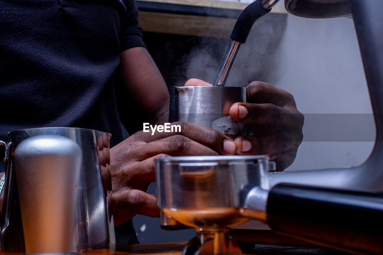 Midsection of man using coffee machine