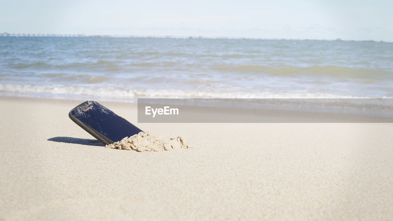 A smartphone in the sand on a beach , copy space for you text